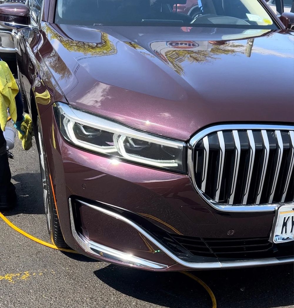 A BMW with a mirror-like finish being hand detailed
